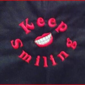keep smiling embroidered on black bag