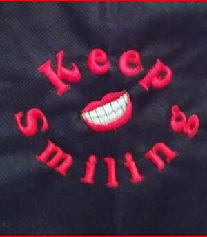 keep smiling embroidered on black bag