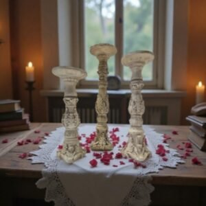 set of 3 architectural candle holders sitting on a table cloth on a table