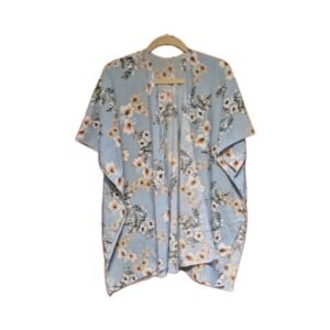 Light blue kimono with white hibiscus floral print, soft silky‑feel fabric, displayed folded on a wooden surface.